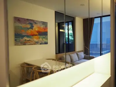 Modern living room with stylish furniture and vibrant artwork, featuring large windows and a cozy atmosphere.