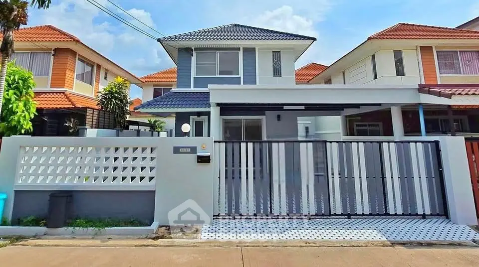 Charming two-story house with modern facade and gated driveway in suburban neighborhood.