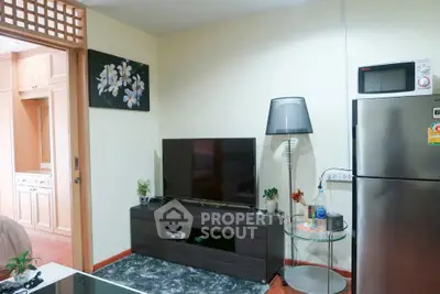 Modern living room with sleek TV setup and stainless steel fridge