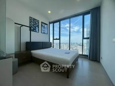 Luxurious bedroom with floor-to-ceiling windows offering stunning city skyline views.