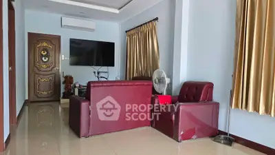 Spacious living room with elegant red leather furniture and modern decor
