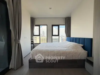Modern bedroom with large windows offering stunning city views, featuring a cozy bed and elegant decor.