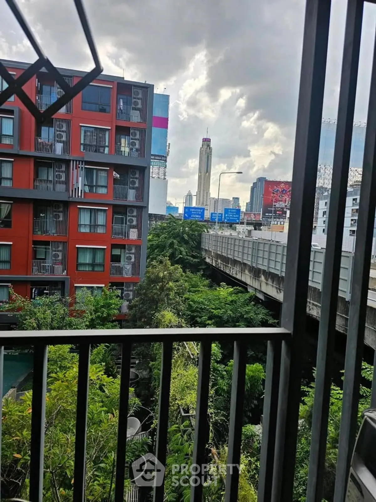 Urban apartment view with lush greenery and cityscape from balcony