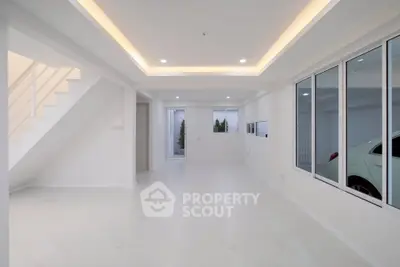 Spacious modern living room with sleek white interior and large windows