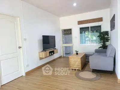 Modern living room with sleek furniture and mounted TV in a cozy setting.