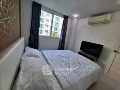 Cozy bedroom with modern decor, featuring a large bed, TV, and air conditioning, perfect for relaxation.