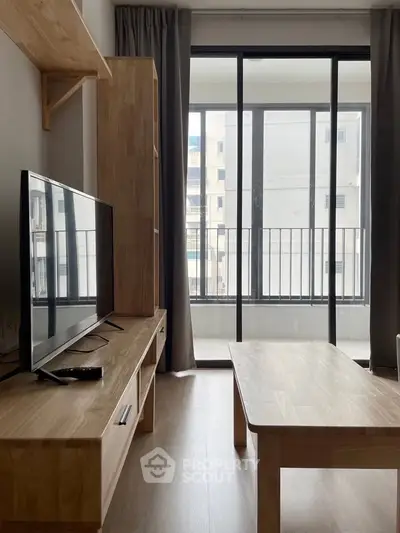 Modern living room with natural light and sleek wooden furniture, featuring a large window with city view.