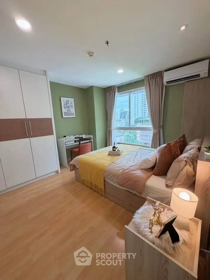 Spacious bedroom with modern decor and city view, featuring a cozy bed and ample storage.