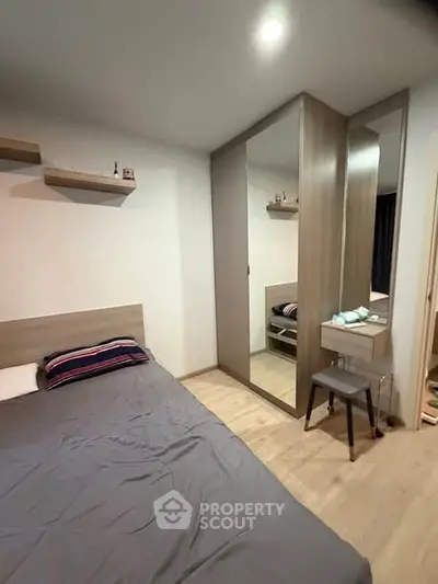 Cozy bedroom with modern decor and mirrored wardrobe in stylish apartment.