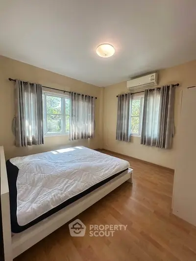 Spacious bedroom with natural light and modern decor in a cozy apartment.