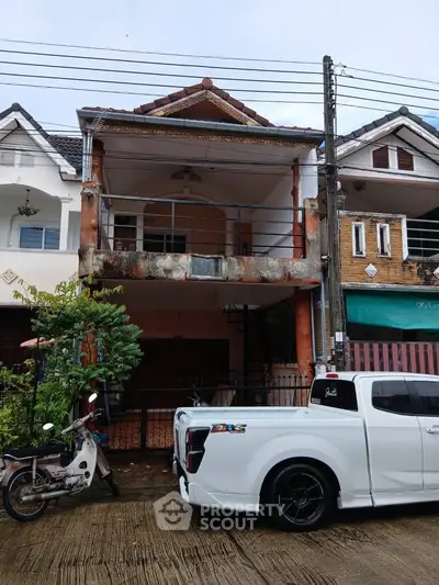 Charming two-story house with balcony and parking space in a residential neighborhood.