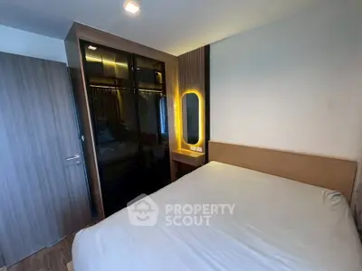 Modern bedroom with sleek wardrobe and illuminated mirror, perfect for stylish living.