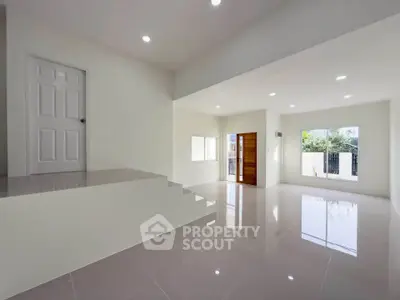 Spacious modern living room with glossy tile flooring and large windows for natural light.