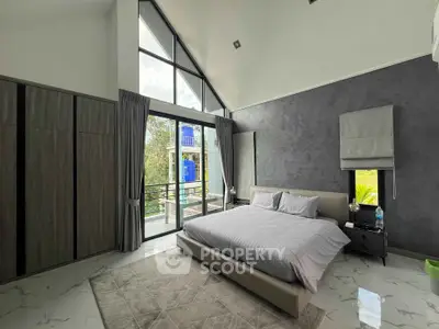 Luxurious bedroom with floor-to-ceiling windows and modern decor, offering serene garden views.