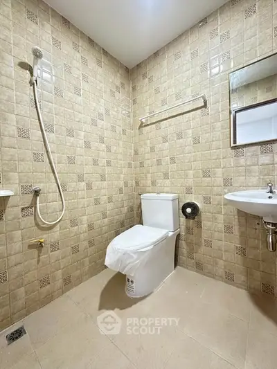 Spacious bathroom with modern fixtures and tiled walls in a real estate property.