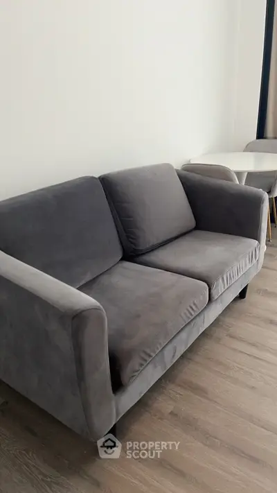 Modern gray sofa in stylish living room with wooden flooring