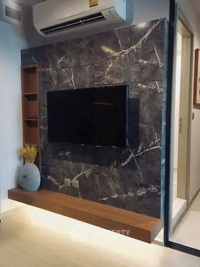 Modern living room with sleek TV wall and air conditioning unit, featuring elegant marble tiles and wooden accents.