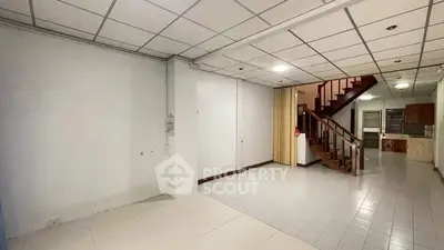 Spacious open-plan interior with staircase and tiled flooring