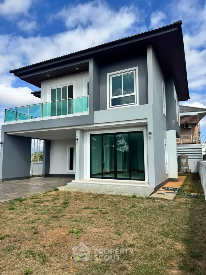 Modern two-story house with large windows and balcony, perfect for family living.