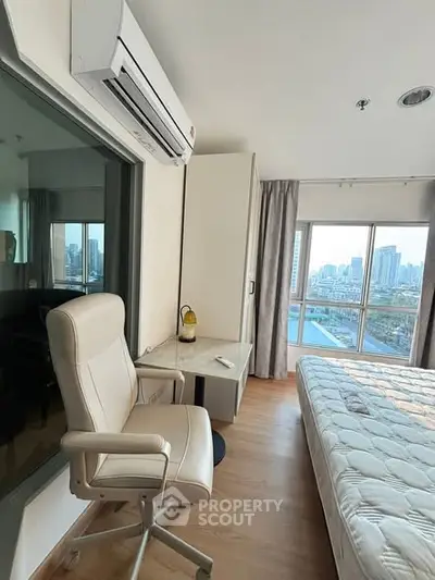 Modern bedroom with city view, featuring sleek furniture and large windows for natural light.