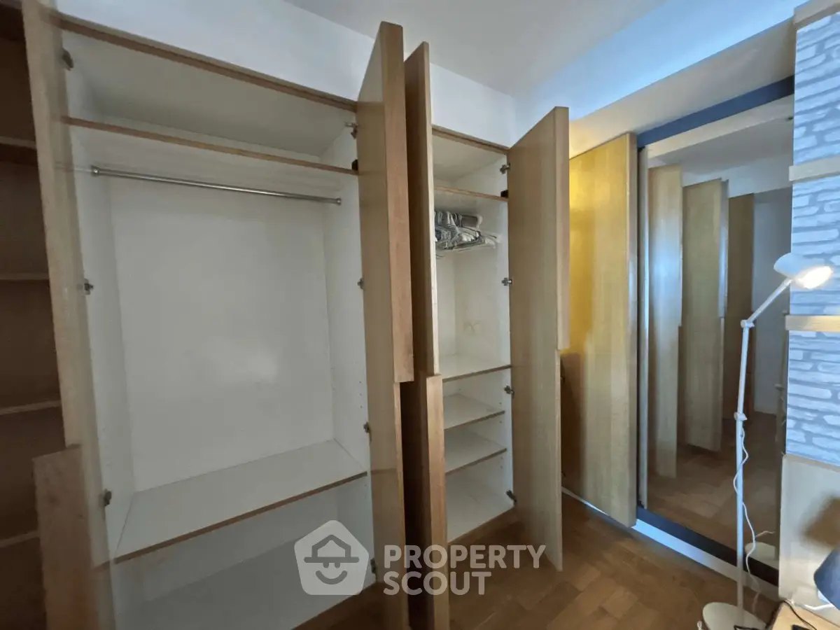 Spacious walk-in closet with wooden shelves and ample storage space.