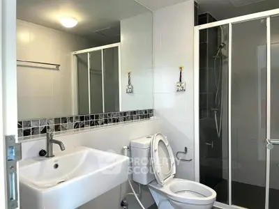 Modern bathroom with sleek shower and stylish sink in a contemporary apartment.