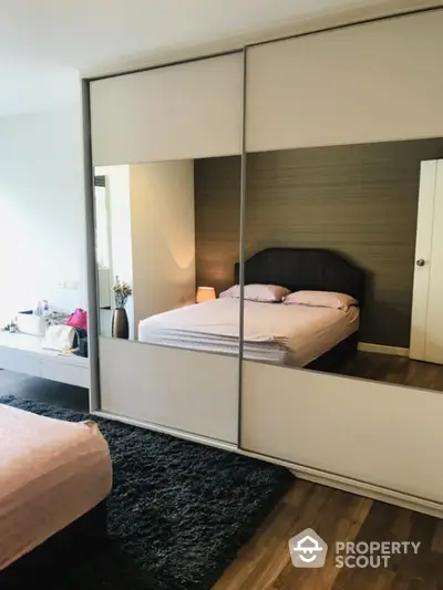 Modern bedroom with mirrored sliding wardrobe and cozy decor