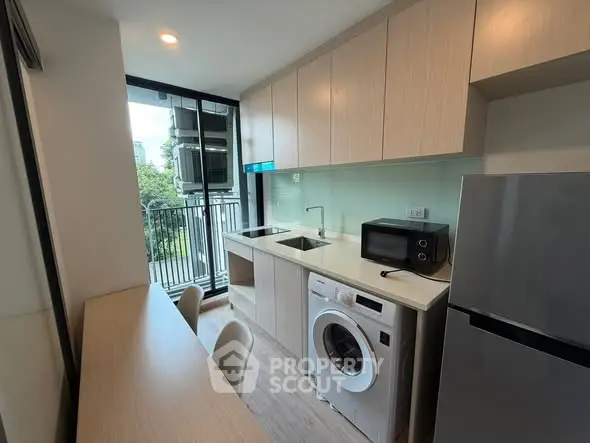 Modern kitchen with washing machine and balcony view