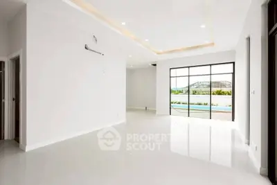 Spacious modern living room with large windows and pool view, perfect for luxury living.