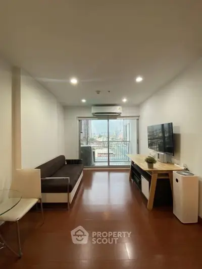 Modern living room with city view, sleek furniture, and large TV, perfect for urban living.