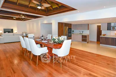 Luxurious open-plan dining and living area with elegant wooden flooring and modern decor.