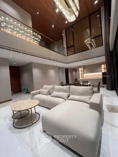 Luxurious modern living room with high ceilings and elegant lighting in a spacious open layout.