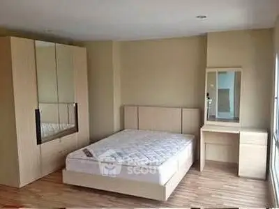 Spacious bedroom with modern wooden furniture and ample natural light.