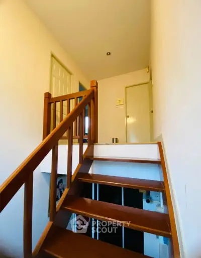 Charming wooden staircase with warm lighting in a cozy home interior
