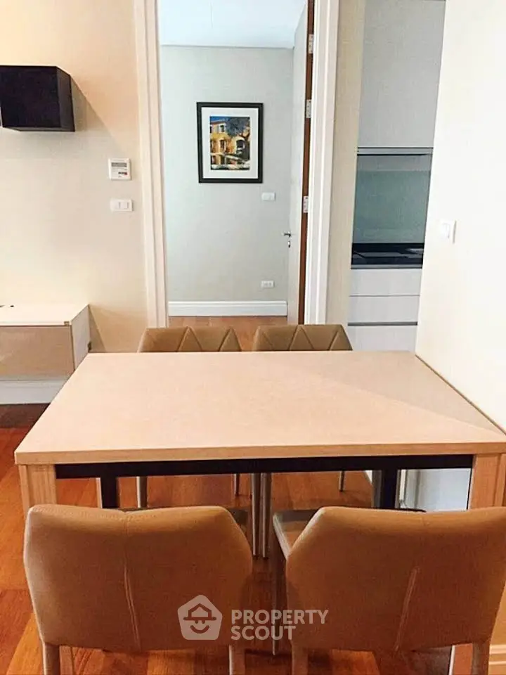 Modern dining area with stylish chairs and wooden flooring in a cozy apartment setting.
