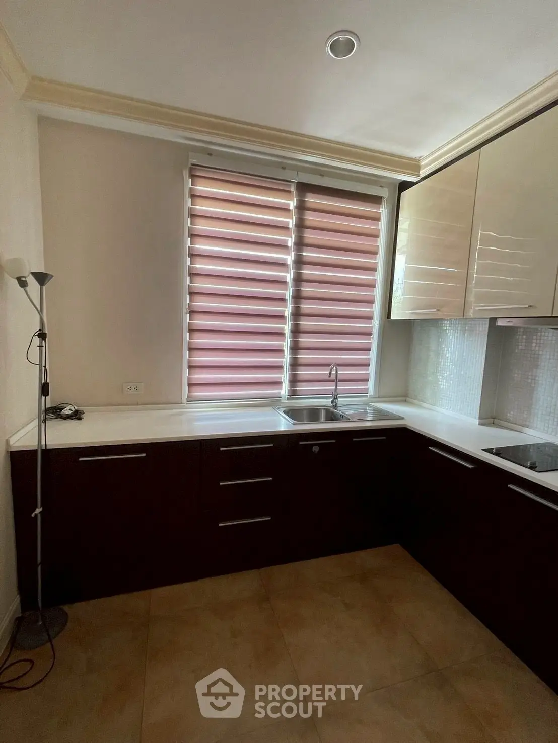 Modern kitchen with sleek cabinetry and large window blinds