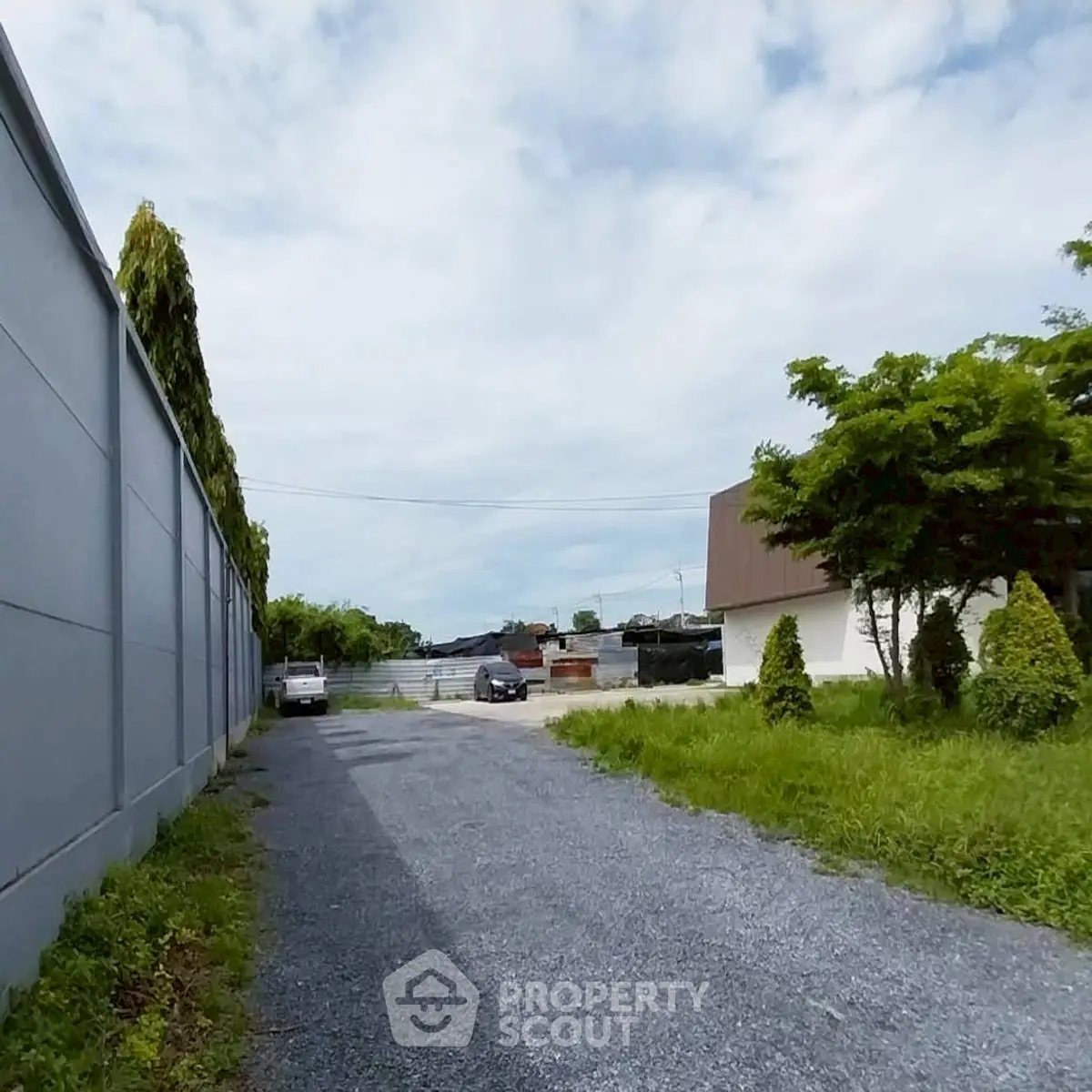 Spacious driveway leading to a serene residential property with lush greenery.