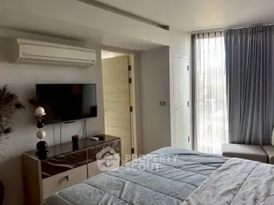 Modern bedroom with air conditioning and stylish decor, featuring a TV and large window with curtains.