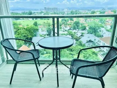 Stunning balcony view with seating overlooking lush greenery and cityscape.