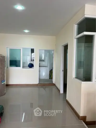 Spacious interior with tiled floors and large windows, ideal for modern living.