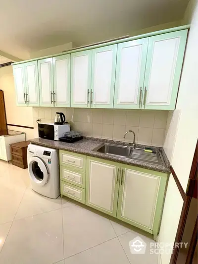 Modern kitchen with mint green cabinets and washing machine