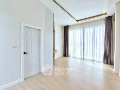 Spacious and bright empty room with large windows and elegant curtains, perfect for customization.