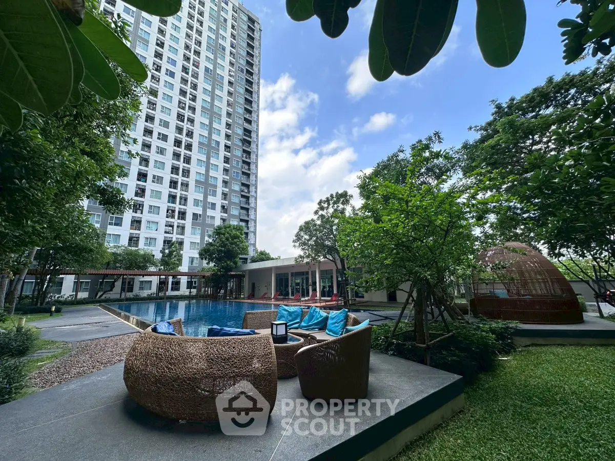 Luxurious apartment complex with poolside seating and lush greenery, perfect for relaxation and leisure.