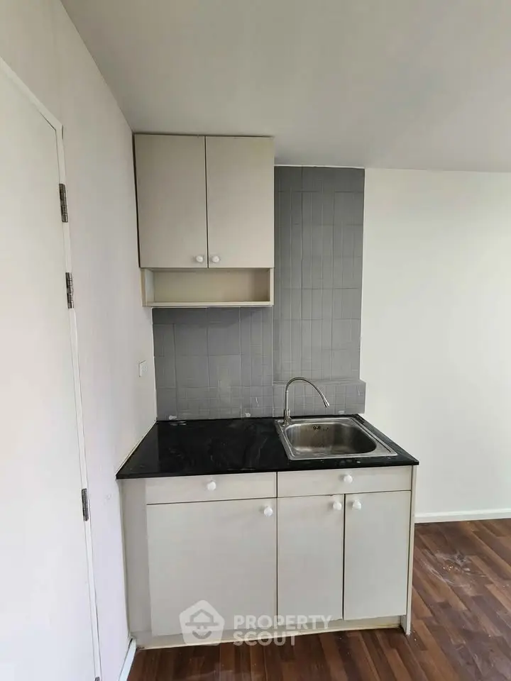 Compact kitchen with sleek cabinetry and modern sink in a cozy apartment.