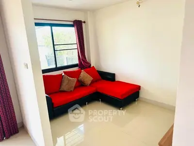 Cozy living room with red sofa and natural light through window