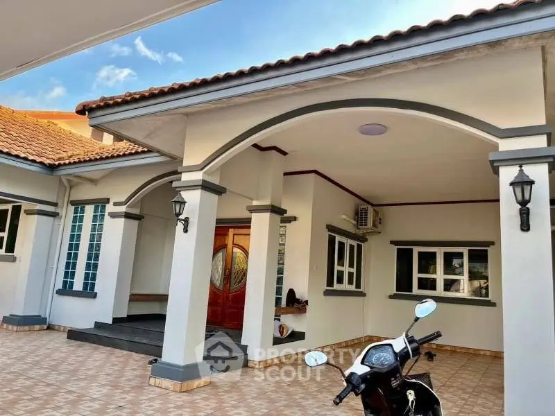 Charming single-story home with tiled patio and elegant archways, perfect for modern living.