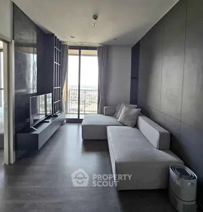Modern living room with sleek furniture and large window offering city view