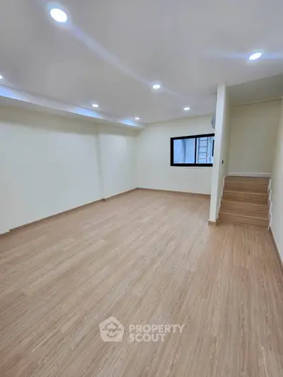 Spacious modern living room with wooden flooring and recessed lighting