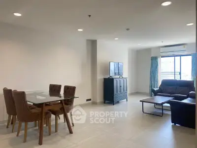 Spacious modern living room with dining area and large windows offering natural light.