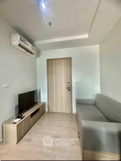 Modern living room with sleek furniture and air conditioning in a contemporary apartment.